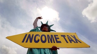 A man holds a sign advertising a tax preparation office for people that still need help completing their taxes before the Internal Revenue Service deadline on April 14, 2010 in Miami, Florida.