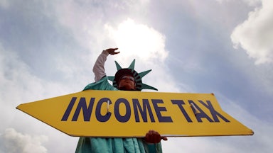 A man holds a sign advertising a tax preparation office for people that still need help completing their taxes before the Internal Revenue Service deadline on April 14, 2010 in Miami, Florida.
