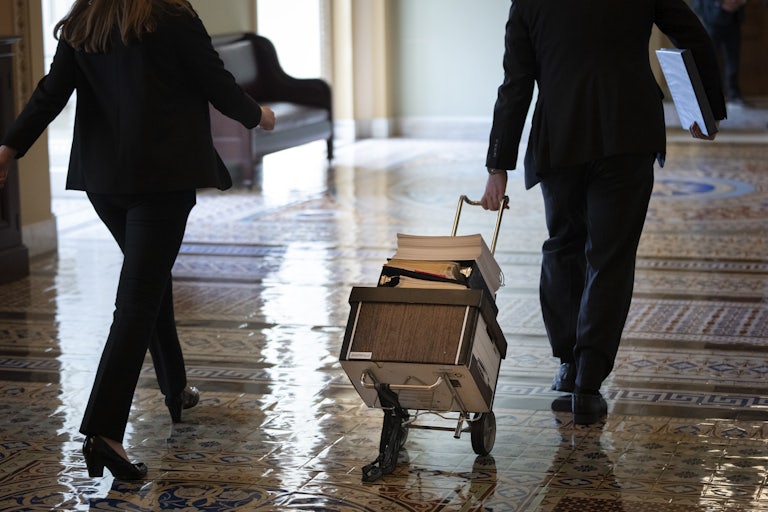 Documents including the text of the bipartisan infrastructure legislation are wheeled toward the office of Senate Majority Leader Chuck Schumer