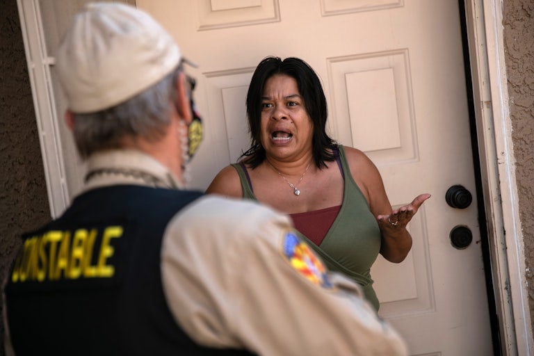 A tenant speaks with a Maricopa County constable who arrived with an eviction order