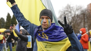 A demonstrator flashes a peace sign at a rally against the war in Ukraine in Seattle.