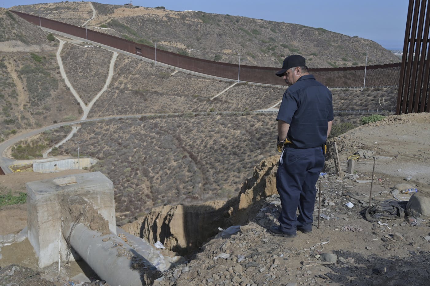 A photo of a Mexican worker in Tijuana’s Matadero Canyon examining a sewage pipeline. During seasonal rains, water from numerous canyons in Tijuana, including nearby Los Laureles, drains into the United States.