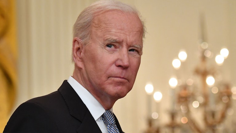 President Joe Biden glances over his right shoulder as he walks through the White House.