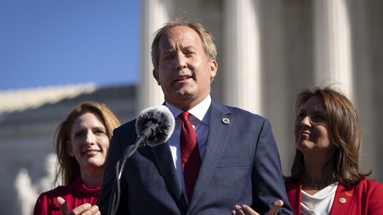 Ken Paxton speaks into a microphone.