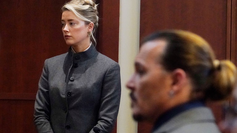 Actress Amber Heard stands as Johnny Depp re-enters the Fairfax County courtroom in which Depp's libel lawsuit is being tried.