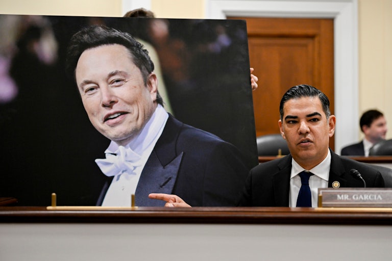 Representative Robert Garcia displays a photo of Elon Musk during a House DOGE hearing