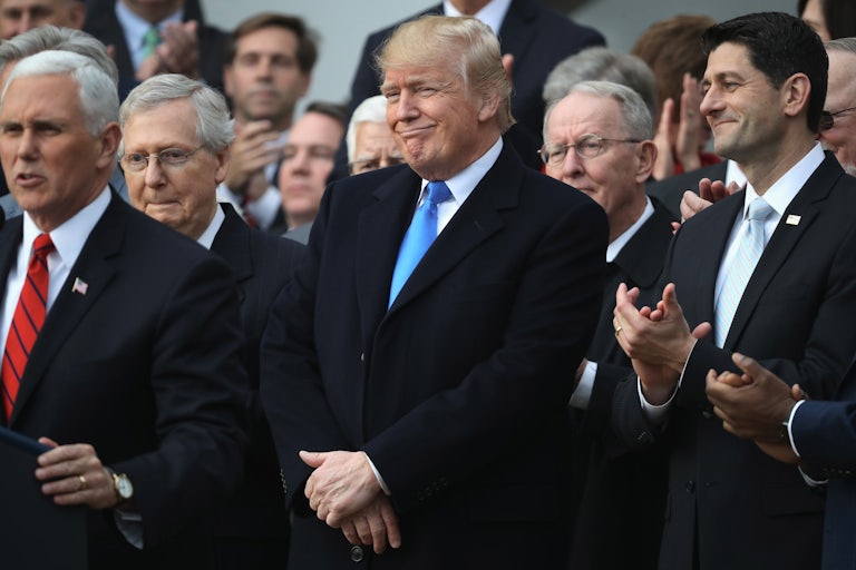 A smirking Donald Trump stands alongside Paul Ryan and Mike Pence.