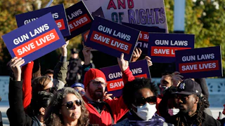 Supporters of gun control hold signs in front of supporters of gun rights during a demonstration by victims of gun violence in front of the Supreme Court.