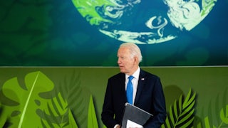 Joe Biden stands, holding a folder.