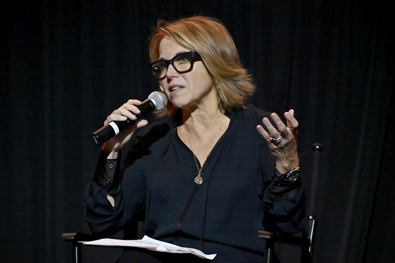 News anchor Katie Couric addresses an audience with a microphone.