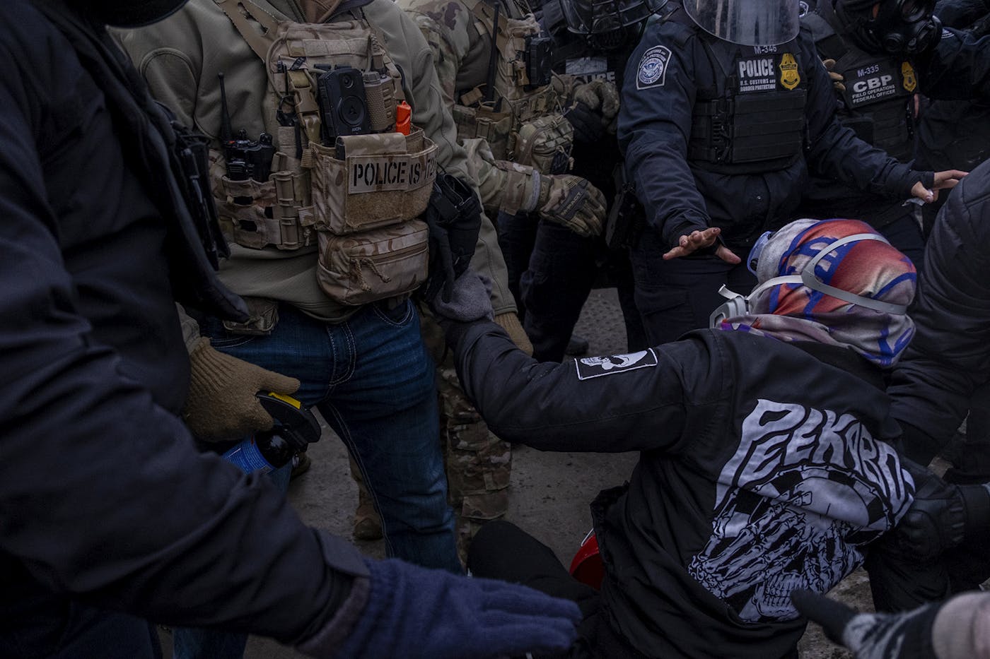ICE agents push a protester