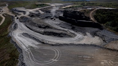 An aerial picture shows a grey expanse cut into the surrounding green landscape.