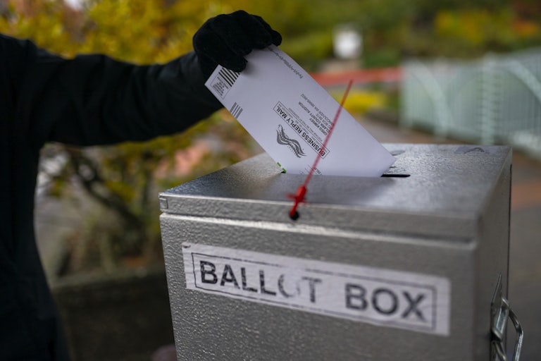 Someone places a ballot in a drop box in Vancouver, Washington