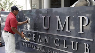 A worker removes the Trump sign letters from outside the hotel in Panama City.