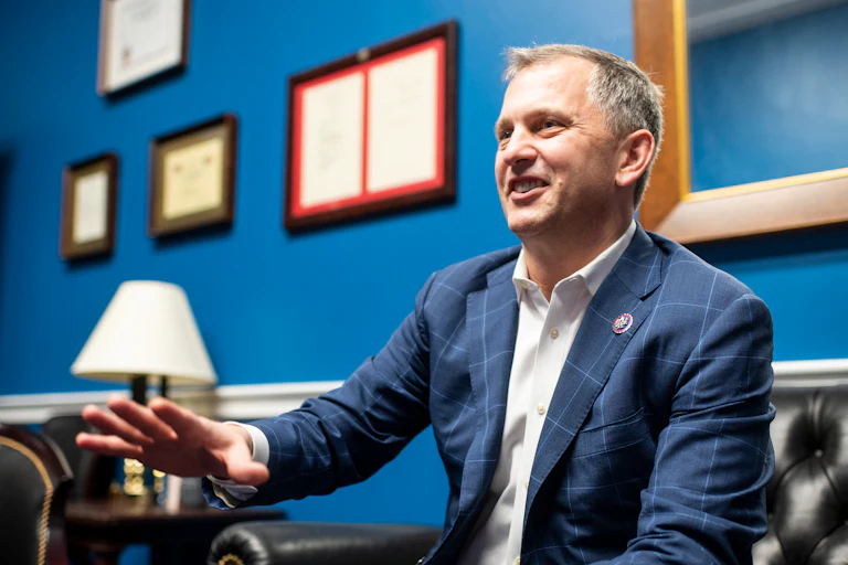 Bill Casten is seated and laughing