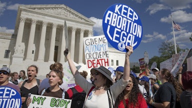 Women hold signs during an abortion rights demonstration in front of the U.S. Supreme Court in Washington, D.C.