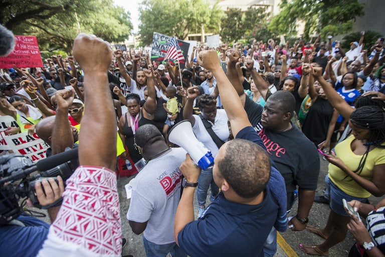 Protesters gather with their fists raised