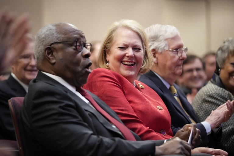 Conservative activist Virginia Thomas sits with her husband, Supreme Court Justice Clarence Thomas, while he waits to speak at the Heritage Foundation.