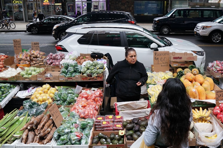 A woman sells produce on a street in the Queens in November of 2019. 
