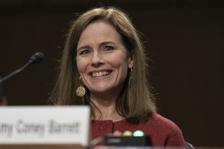 Amy Coney Barrett smiles while testifying before the Senate Judiciary Committee.