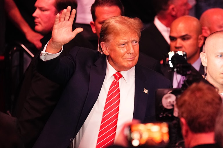 Donald Trump waves as he stands in a crowd