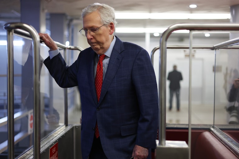 Mitch McConnell takes the subway in the Capitol. He glances downard as if forlorn.