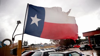 A torn state flag of Texas hangs on a staff in Houston.