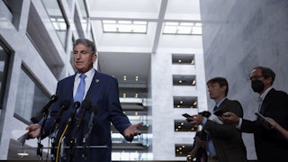 Joe Manchin gestures while speaking to reporters.