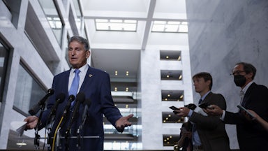 Joe Manchin gestures while speaking to reporters.