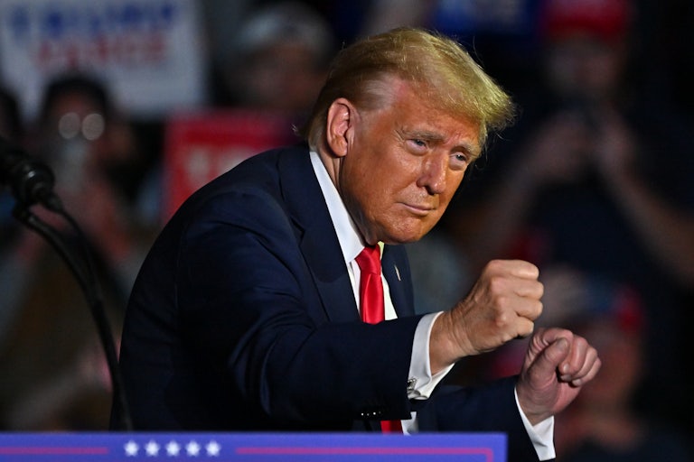 Donald Trump holds his fists up and dances at a campaign event