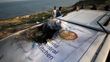 Palestinians check a World Central Kitchen vehicle struck by Israeli drones