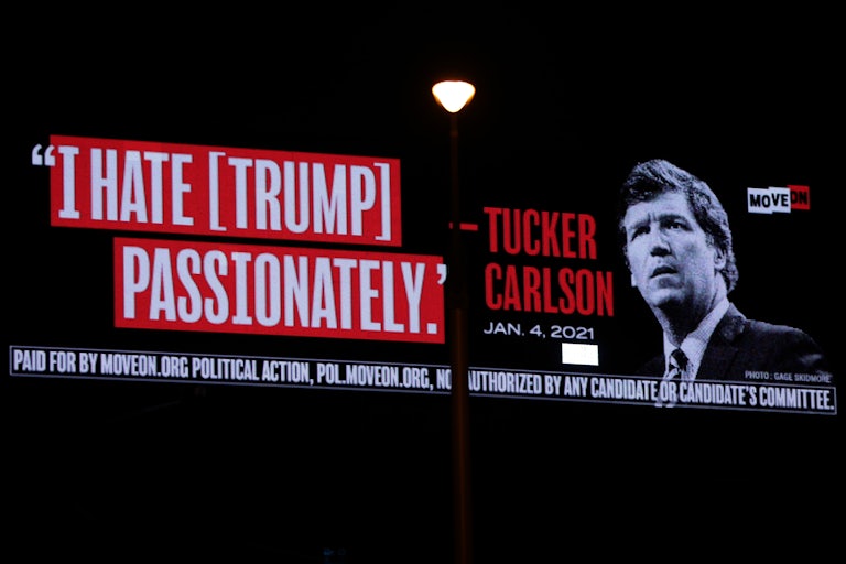 A billboard put up by progressive activist group MoveOn that reads “I Hate [Trump] Passionately - Tucker Carlson, January 4, 2021" and a photo of him looking confused.