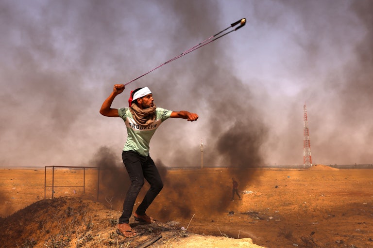 A Palestinian demonstrator hurls a rock during a protest in the Gaza Strip.
