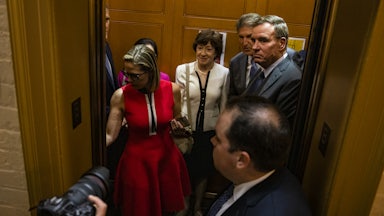 Senators Kyrsten Sinema, Susan Collins, Joe Manchin, and Mark Warner board an elevator in the Capitol building 