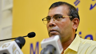 Mohamad Nasheed speaks in front of several microphones.