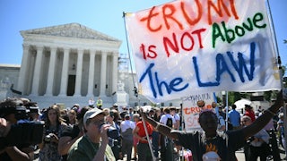 People hold anti-Trump signs in front of the U.S. Supreme Court on July 1 in Washington, D.C.