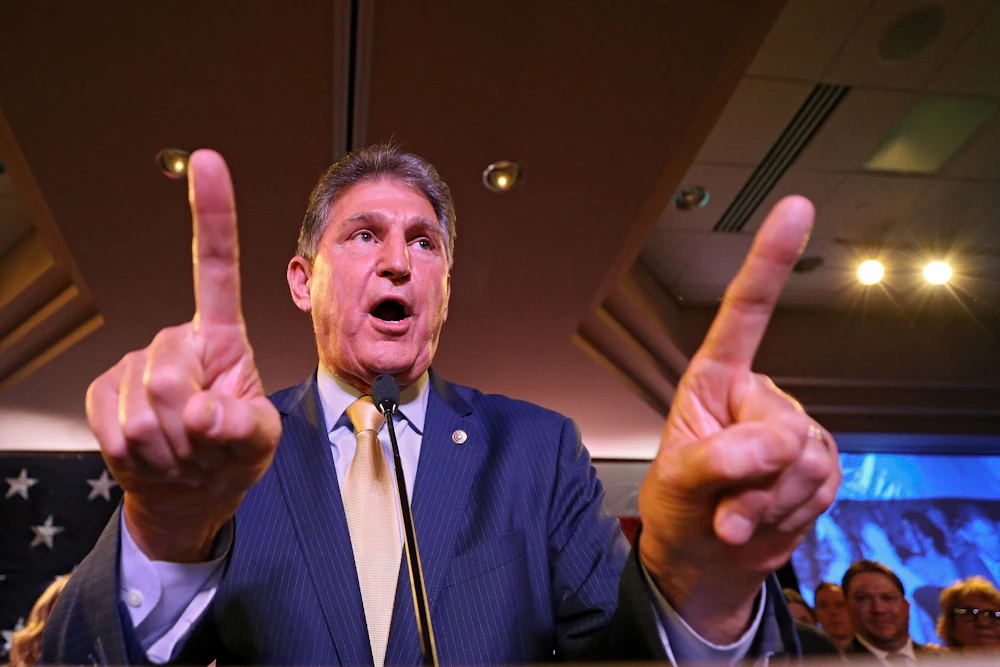 Senator Joe Manchin gesticulates enthusiastically at a gathering of voters.