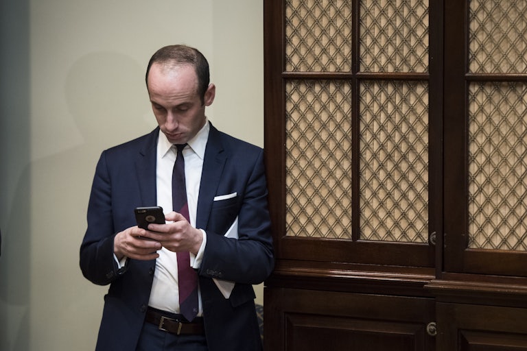 Stephen Miller looks at his phone