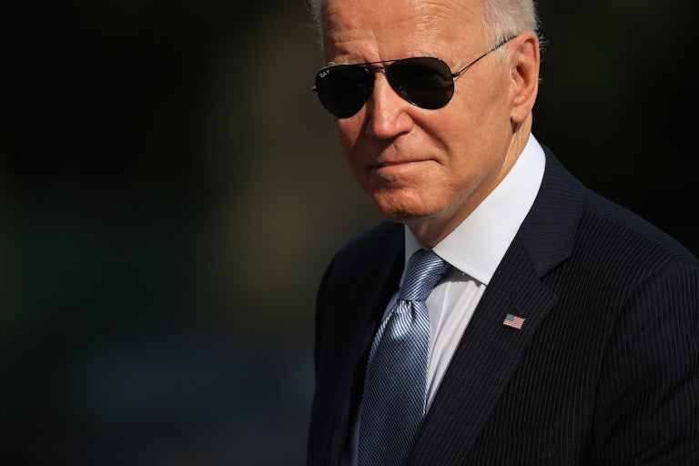 Joe Biden, in dark sunglasses, walks across the White House's South Lawn
