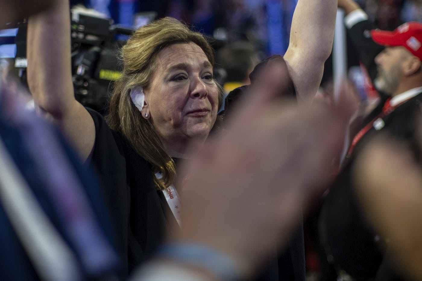 a photograph of a woman wearing an ear bandagesat the Republican National Convention to express sympathy with Donald Trump