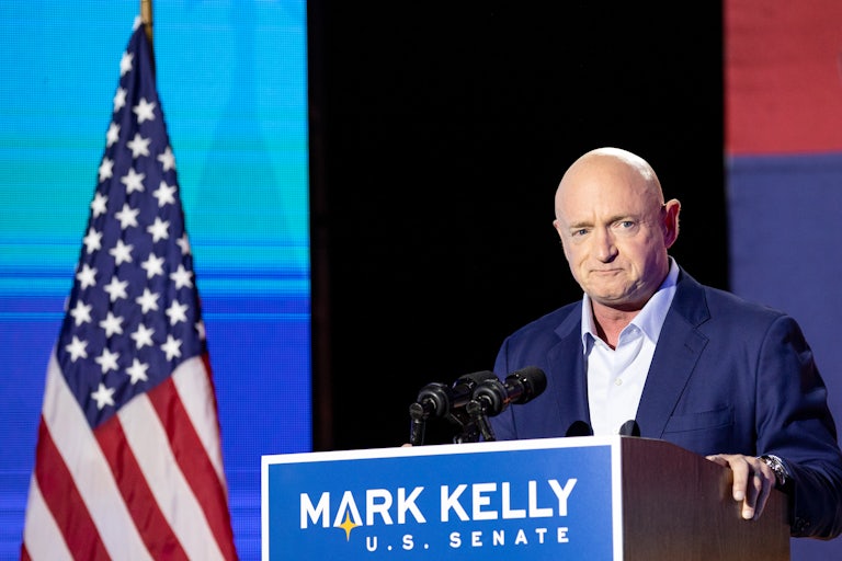Mark Kelly speaks to supporters at a podium that reads “Mark Kelly for U.S. Senate”