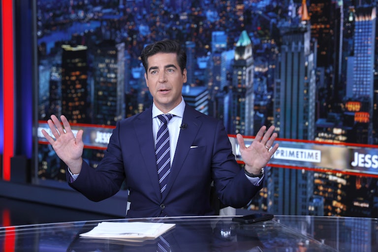 Jesse Watters on the Fox News set raises his hands as if in defense
