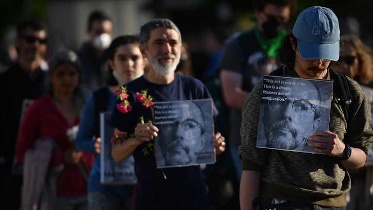 People hold signs with Wynn Bruce's picture.