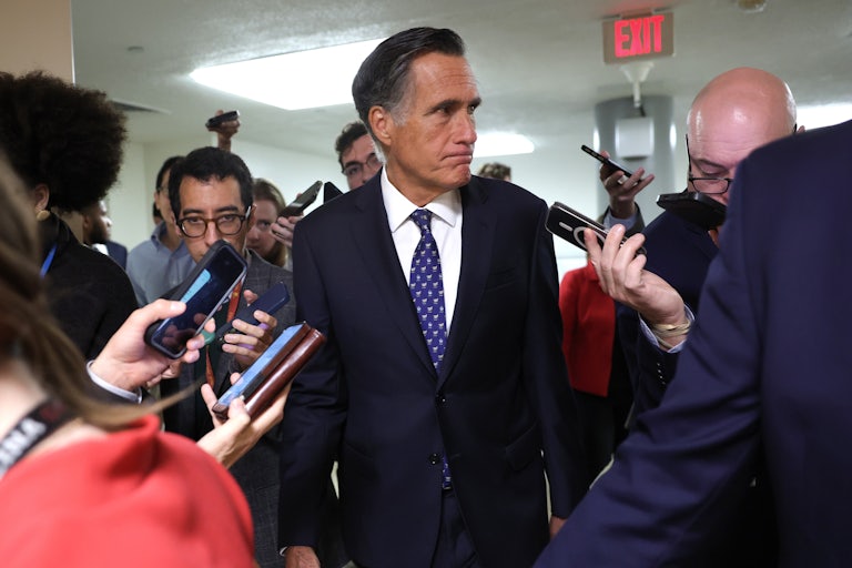 Senator Mitt Romney makes a face as he talks to the press