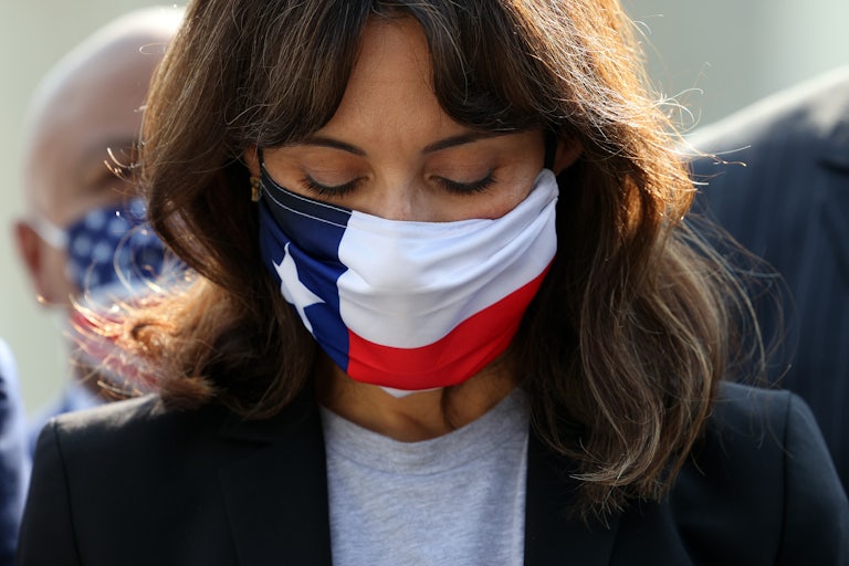 A close-up of a masked Texas State Representatives Gina Hinojosa, looking downwards.
