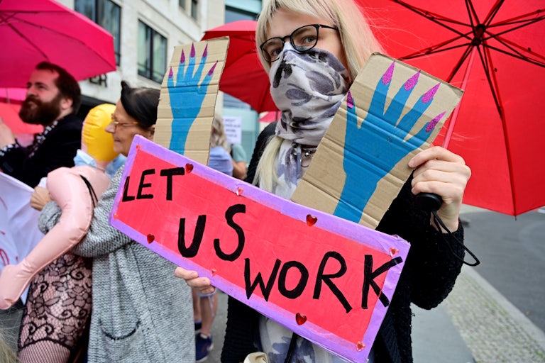 Sex workers hold placards during a protest