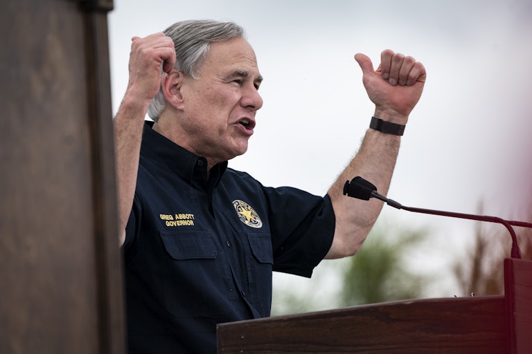 Texas Governor Greg Abbott raises his arms for emphasis at a rally.