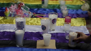 Candles are set on top of the nonbinary and pride flags