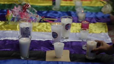 Candles are set on top of the nonbinary and pride flags