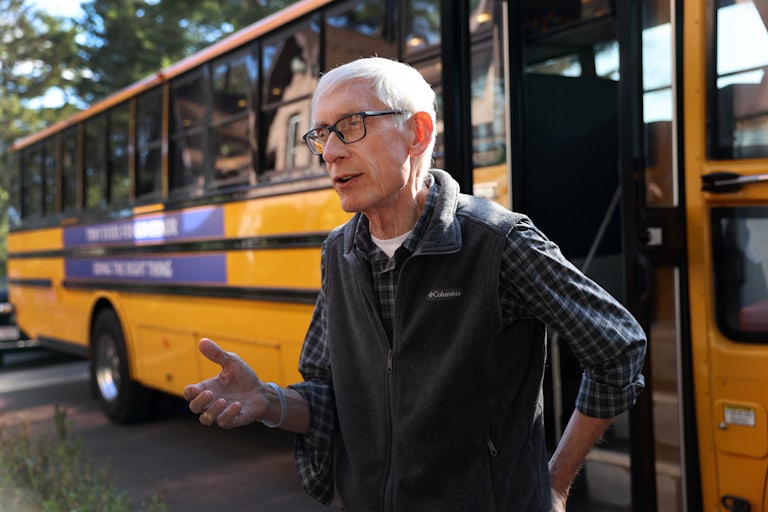 Wisconsin Governor Tony Evers stands in front of a school bus